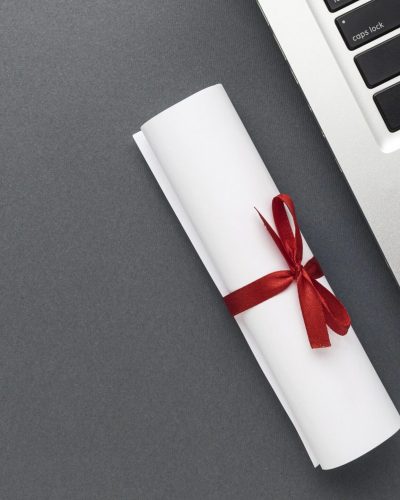 top-view-laptop-with-glasses-diploma